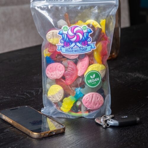 Zak veggie snoep op tafel, sfeerfoto met telefoon en sleutels